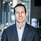 Smiling businessman in navy suit standing indoors