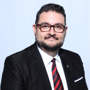 Professional headshot of bearded man in suit and striped tie
