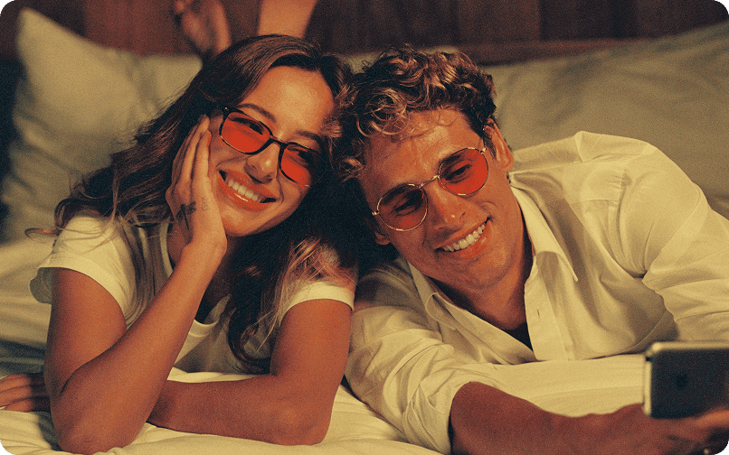 Smiling couple in tinted sunglasses taking a selfie